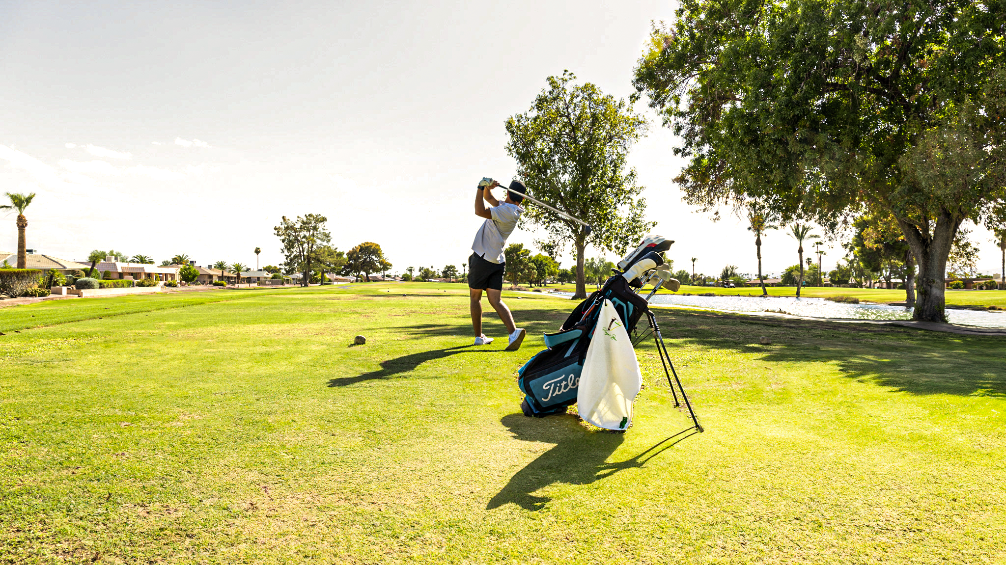 white golf towel on golf bag with golfer in background