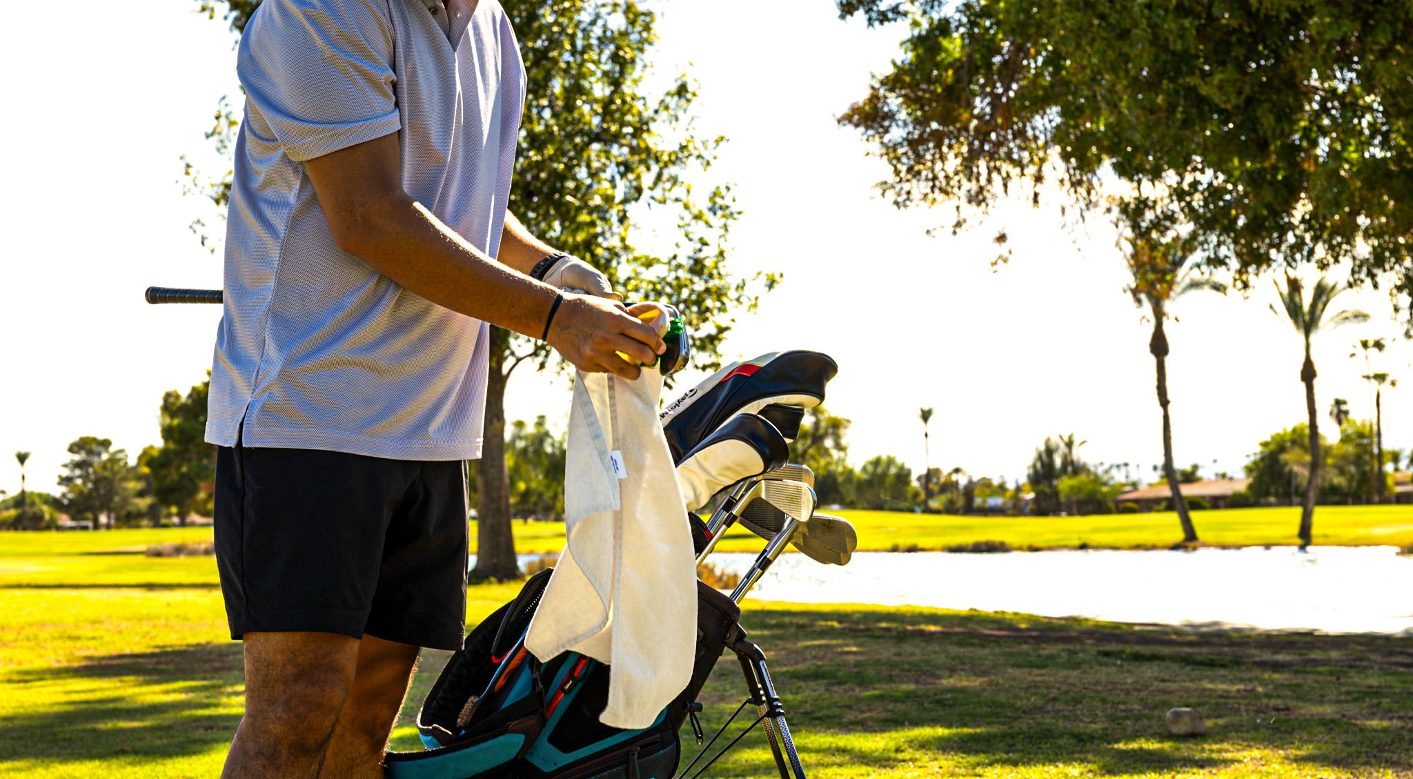 golfer cleaning their club with a Player Bee golf towel