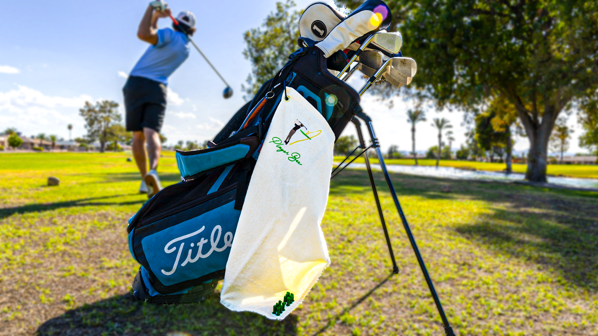 Player Bee golf towel on a golf bag with golfer in the background