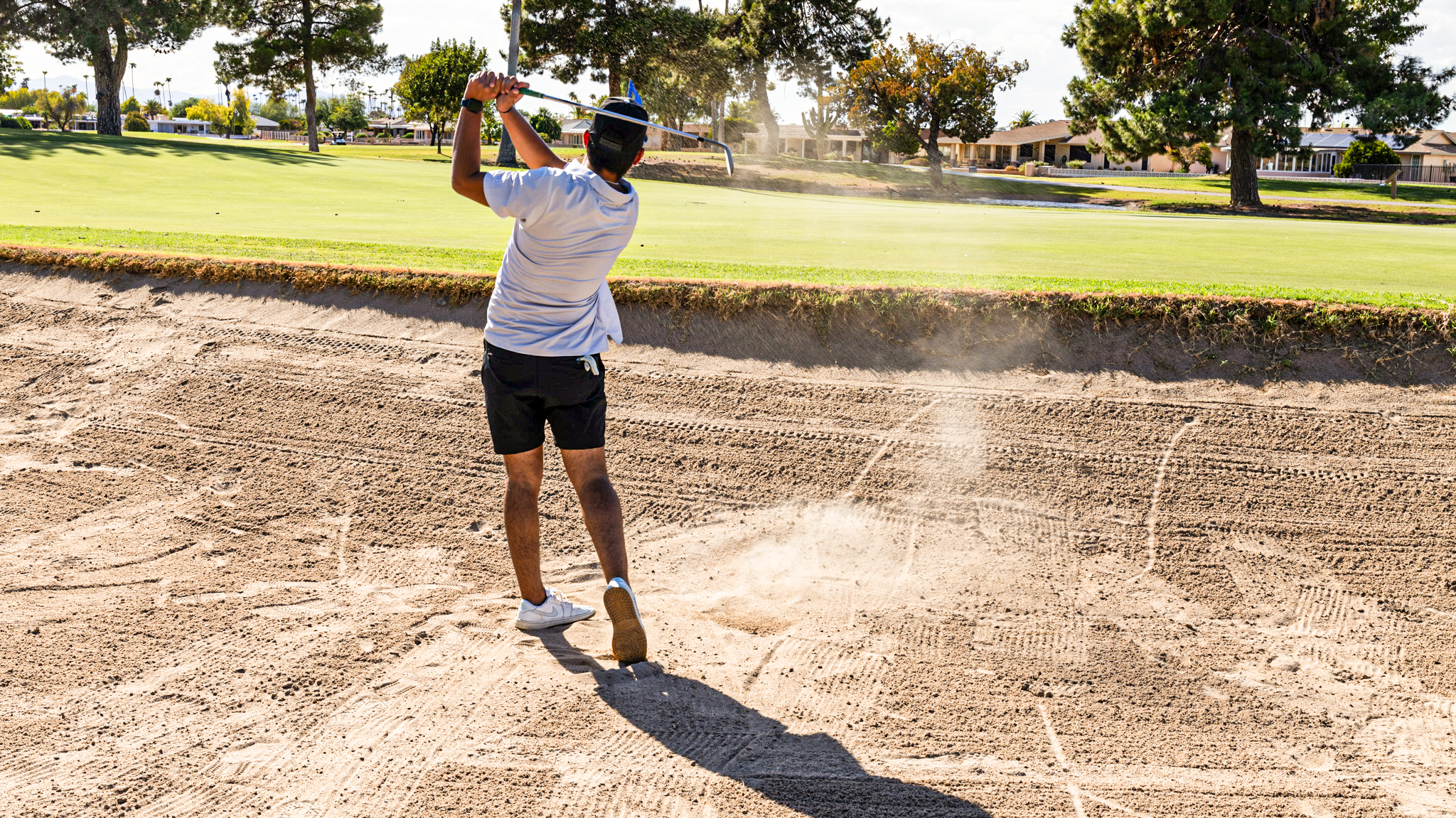 golfer hitting a sand shot, golf towel